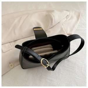 Interior view of black baguette bag showing phone and quilted wallet storage space