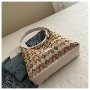 Detail of bohemian geometric woven tote bag with pearl pendant and ivory leather handles