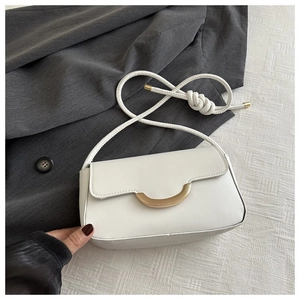 Détail d'un sac à rabat blanc avec fermoir doré et bandoulière en corde tressée chic