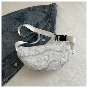 Close-up of white bubble texture fabric on a cross-body bag with durable nylon strap