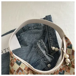 Detail of hobo bag with colorful geometric brocade pattern and white leather strap