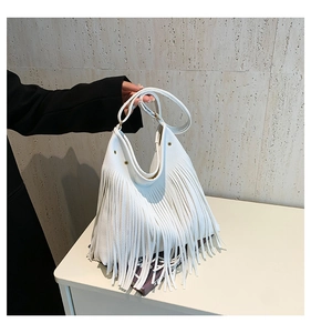 Close-up of bohemian white tote bag with long fringes and pebbled leather texture