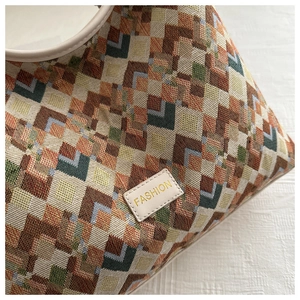 Close-up of woven geometric fabric texture and leather fashion tag on tote bag