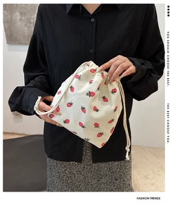 Détail d'un sac seau en velours côtelé blanc avec motif fraise rouge mignon