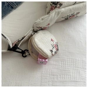 Détail du sac bandoulière en velours côtelé fleuri avec petite pochette à rouge à lèvres