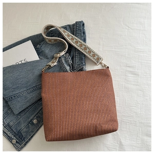 Close-up of brown woven tote bag featuring a bohemian patterned wide jacquard shoulder strap