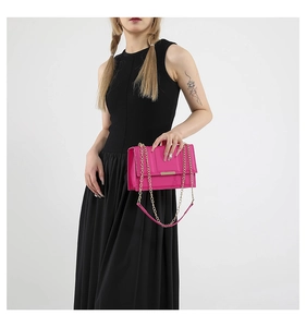 Detail of rose red flap crossbody bag featuring gold chain strap and metal buckle closure