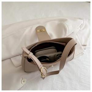 Detail view of beige baguette bag interior with smooth leather and golden buckle