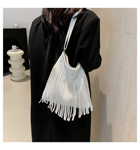 Detail of white bohemian tassel shoulder bag on model with soft fringe movement