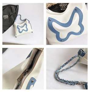 Details der weißen Schultertasche mit blauem Schmetterling, Nieten und Kettenriemen