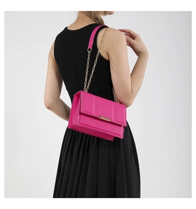 Side view of structured magenta chain bag featuring elegant gold hardware and accordion folds