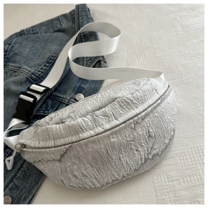 Detailed macro view of white crinkle textured fabric waist bag with durable black buckle