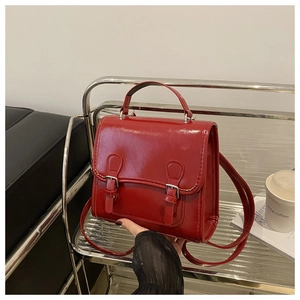 Handheld red vintage leather backpack with double buckles and adjustable straps