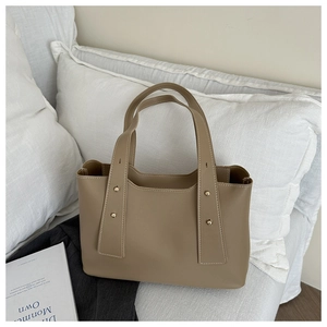 Detail of khaki leather tote bag with gold rivets and white contrast stitching