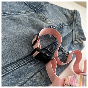 Détail de la bandoulière en nylon rose avec boucle noire sur un sac à bandoulière tendance