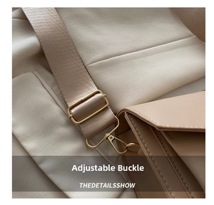 Close-up of adjustable nylon strap with gold metal buckle on a beige leather crossbody bag