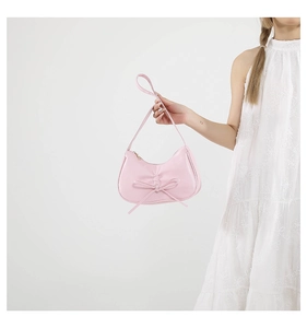 Détail du sac sous l'aisselle plissé rose avec un nœud délicat et cuir lisse poli