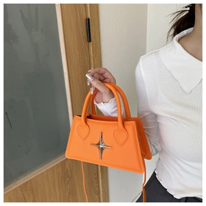 Détail d'un sac à main orange vif avec décoration d'étoile métallique argentée