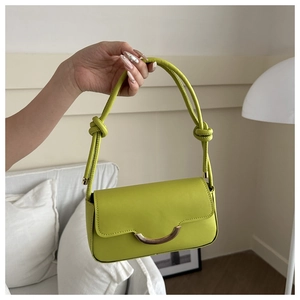 Détail du sac à bandoulière vert citron avec boucle en croissant et sangle à nœuds