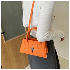 Détail du sac bandoulière orange avec boucle étoile argentée et aspect cuir texturé