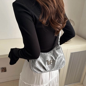 Borsa sottoascellare pieghettata argento metallizzato con farfalla indossata dal modello
