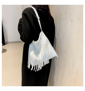 Detail of white lychee leather tote bag with long tassels and golden metal rivets