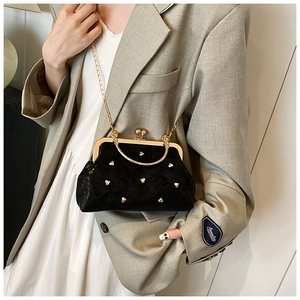 Dettaglio della pochette in velluto nero con borchie a cuore e catena dorata