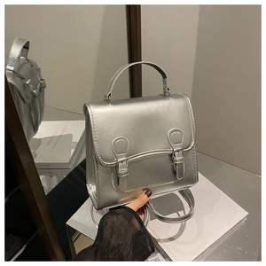 Close-up of silver faux leather crossbody bag with lychee texture and buckle details