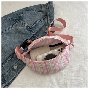 Vue de dessus du sac bandoulière rayé ouvert avec espace pour téléphone et maquillage