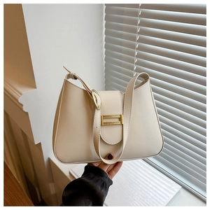 Detail of off-white minimalist shoulder bag with a gold metal buckle and smooth leather