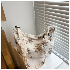 Détail du sac bandoulière en velours côtelé fleuri vintage avec son petit pendentif assorti