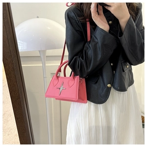 Détail du sac bandoulière rose avec étoile argentée porté par un mannequin stylé