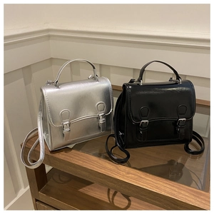 Detail of vintage flap satchels in glossy silver and black leather with silver buckles
