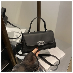 Detail of matte black leather handbag with crocodile pattern sides and silver buckle