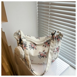 Détails de la texture du sac bandoulière en velours côtelé ivoire avec motifs floraux roses