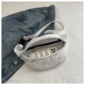 Detail of white bubble textured waist bag showing interior storage for phone and cards