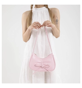 Gros plan d'un sac à épaule en cuir PU rose pâle avec un nœud décoratif élégant