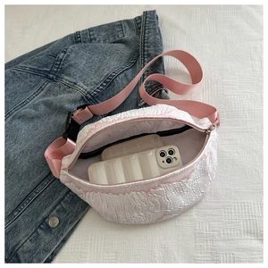 Detail showing pink bubble textured crossbody bag capacity with phone and wallet