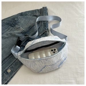 Close-up of the light blue bubble textured chest bag showing internal capacity and lining