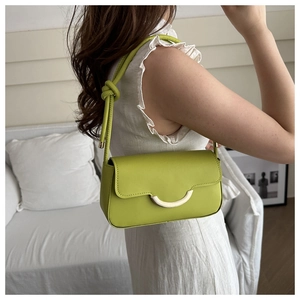 Détail du sac à bandoulière vert avocat avec boucle en croissant doré et bandoulière nouée