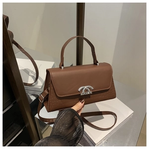 Detail of a brown PU leather crossbody bag featuring a silver metal twist lock and handle