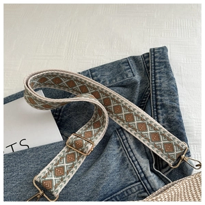 Close-up of geometric ethnic guitar-style bag strap with gold metal hooks and adjusters