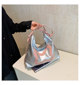 Detail der silbernen Metallic-Hobo-Tasche mit rosa Leder-Schmetterling und Metallnieten