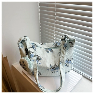 Détail du sac bandoulière floral en nylon avec mini pochette et texture velours