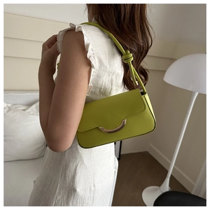 Détail du sac baguette en cuir vert citron avec boucle métal et bandoulière nouée