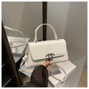 Detail view of white crossbody bag with crocodile texture and silver metal buckle