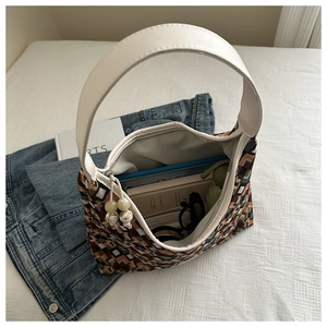 Top view of woven nylon tote bag interior with colorful geometric patterns and white strap