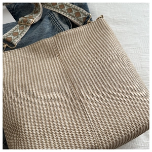 Close-up of woven bucket bag texture with ethnic style diamond pattern shoulder strap