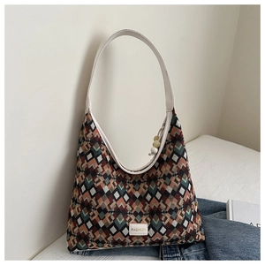 Detail of multi-color geometric diamond pattern fabric and white fashion label on tote bag