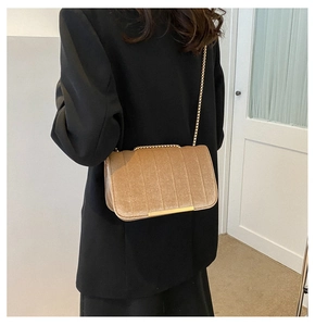 Detail of khaki velvet crossbody bag with gold chain strap and vertical stripe stitching